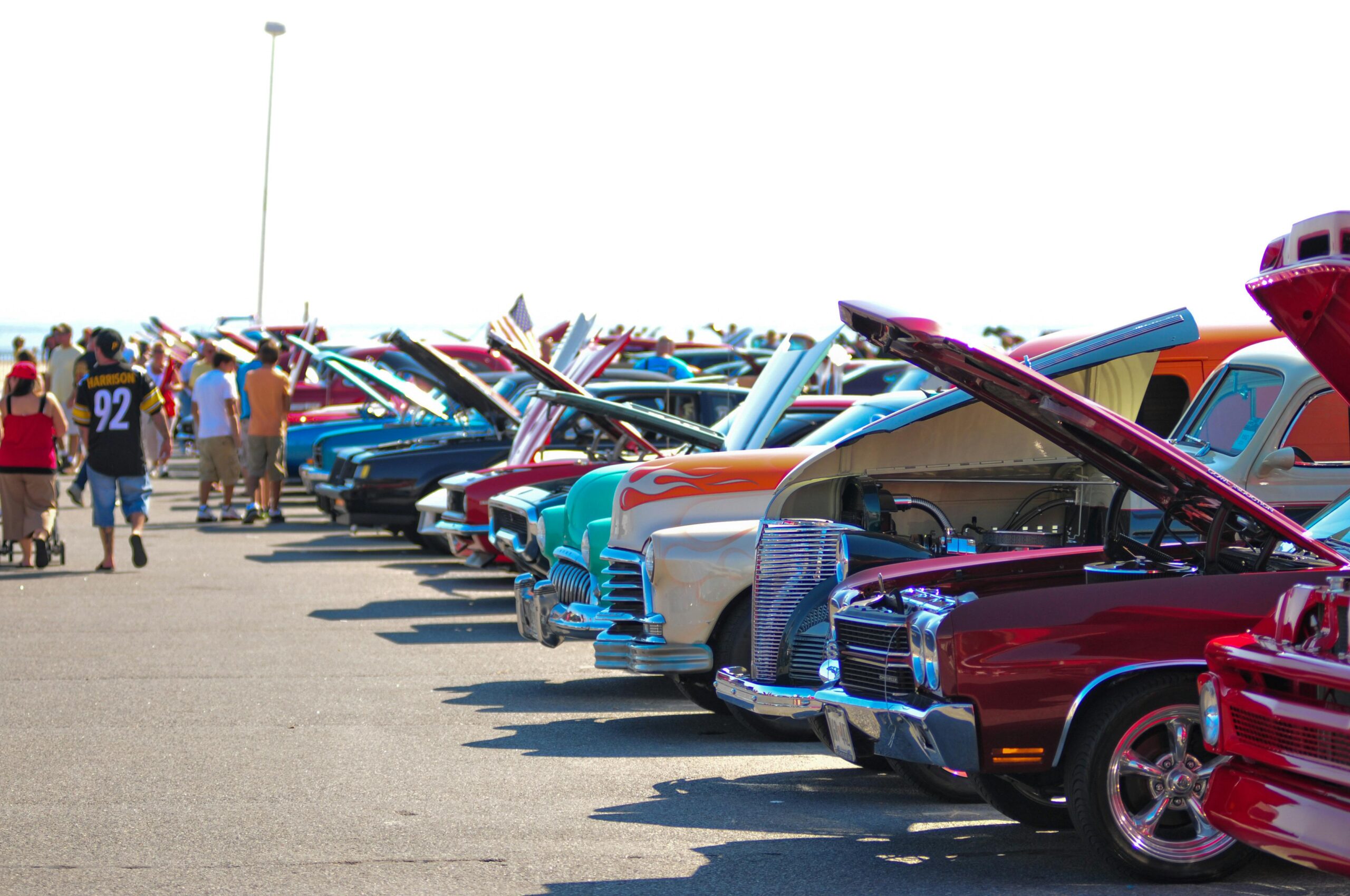 Colorful classic cars on display outdoors at a sunny car show.